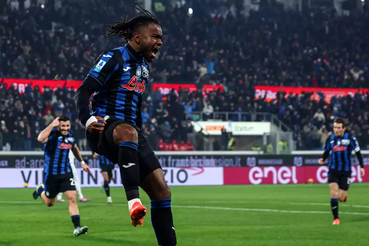 Football player celebrating a goal in a stadium full of spectators.