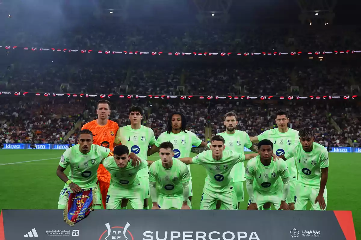 A soccer team posing for a photo before a match in a stadium full of spectators. A soccer team posing for a photo before a match in a stadium full of spectators.