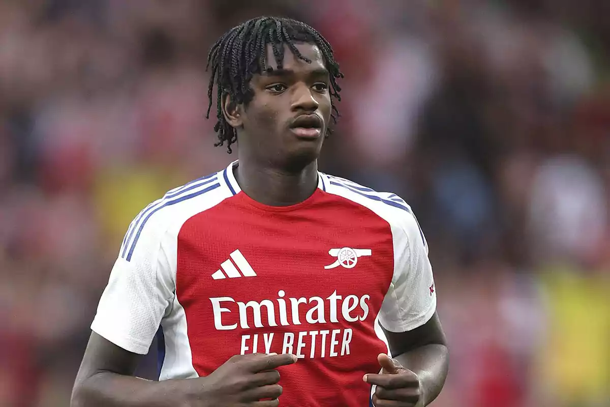 A football player in an Arsenal uniform during a match. A football player in an Arsenal uniform during a match.