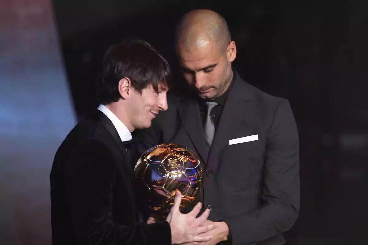 Dos personas elegantemente vestidas sostienen un trofeo dorado en un evento formal. Dos personas elegantemente vestidas sostienen un trofeo dorado en un evento formal.