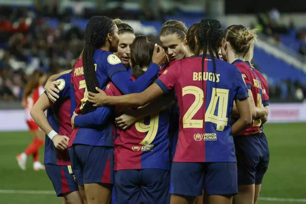 Female players celebrating in a group on the field. Female players celebrating in a group on the field.