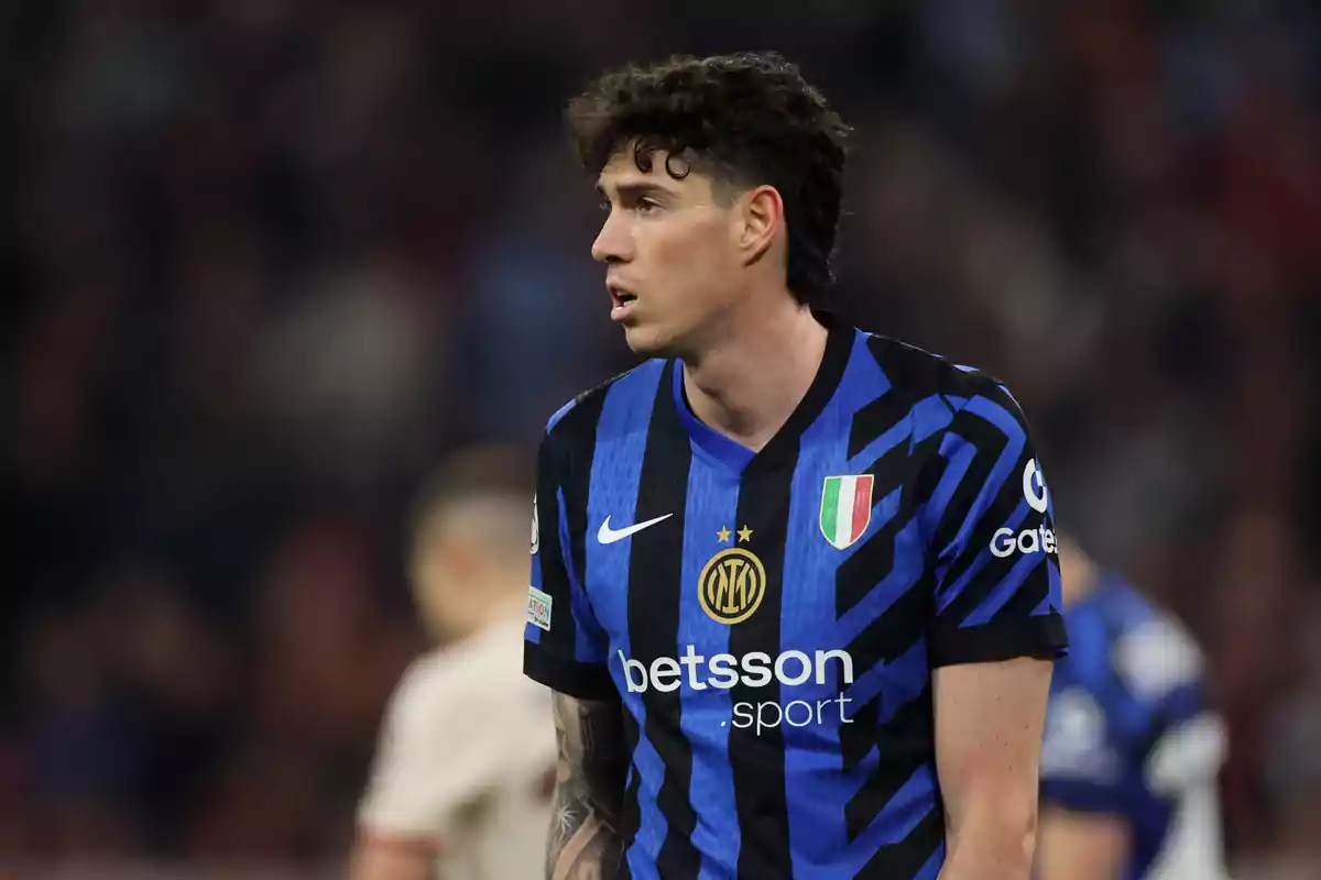 Jugador de fútbol con uniforme azul y negro durante un partido. Jugador de fútbol con uniforme azul y negro durante un partido.