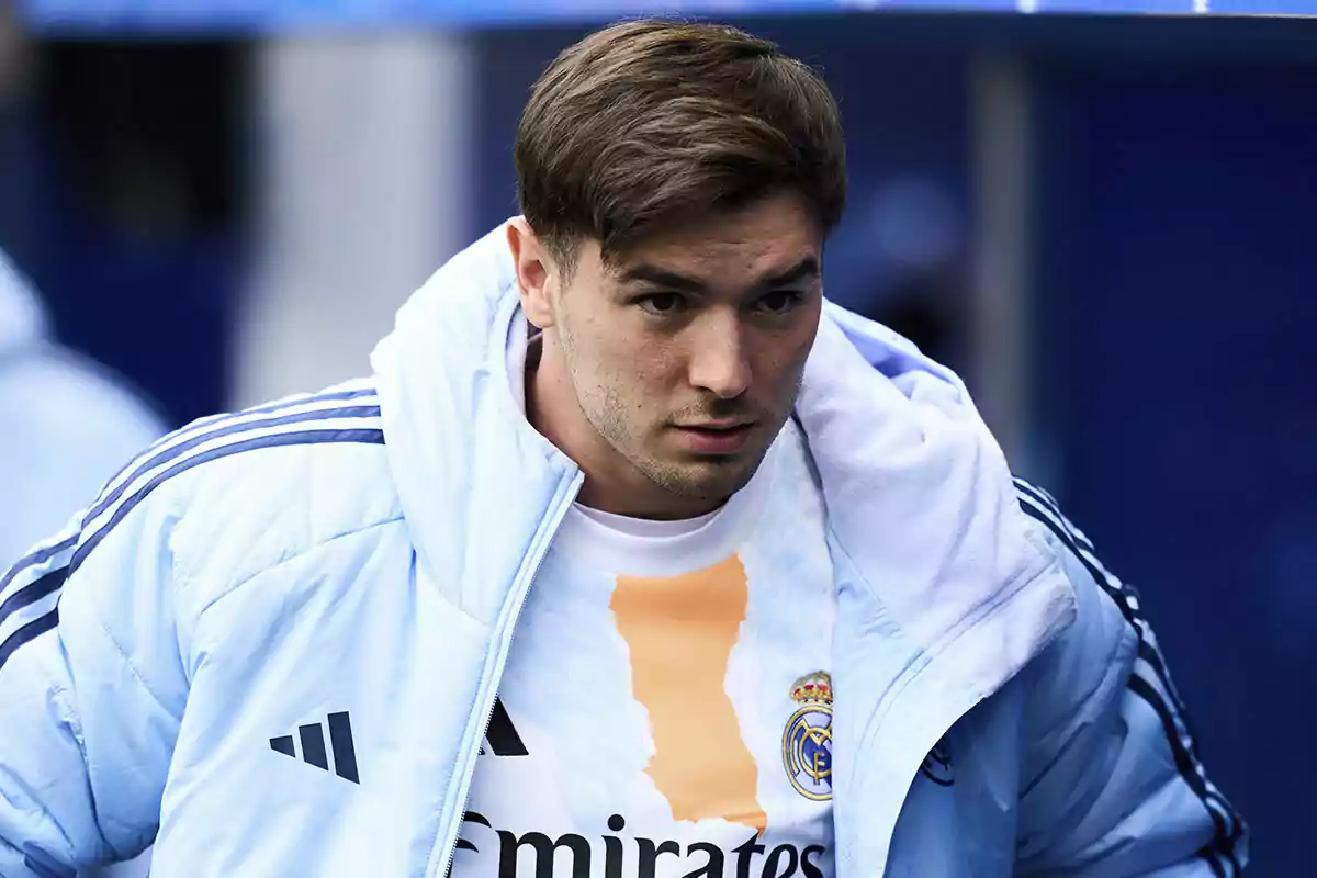 Jugador de fútbol con chaqueta y camiseta del Real Madrid preparándose antes de un partido Jugador de fútbol con chaqueta y camiseta del Real Madrid preparándose antes de un partido