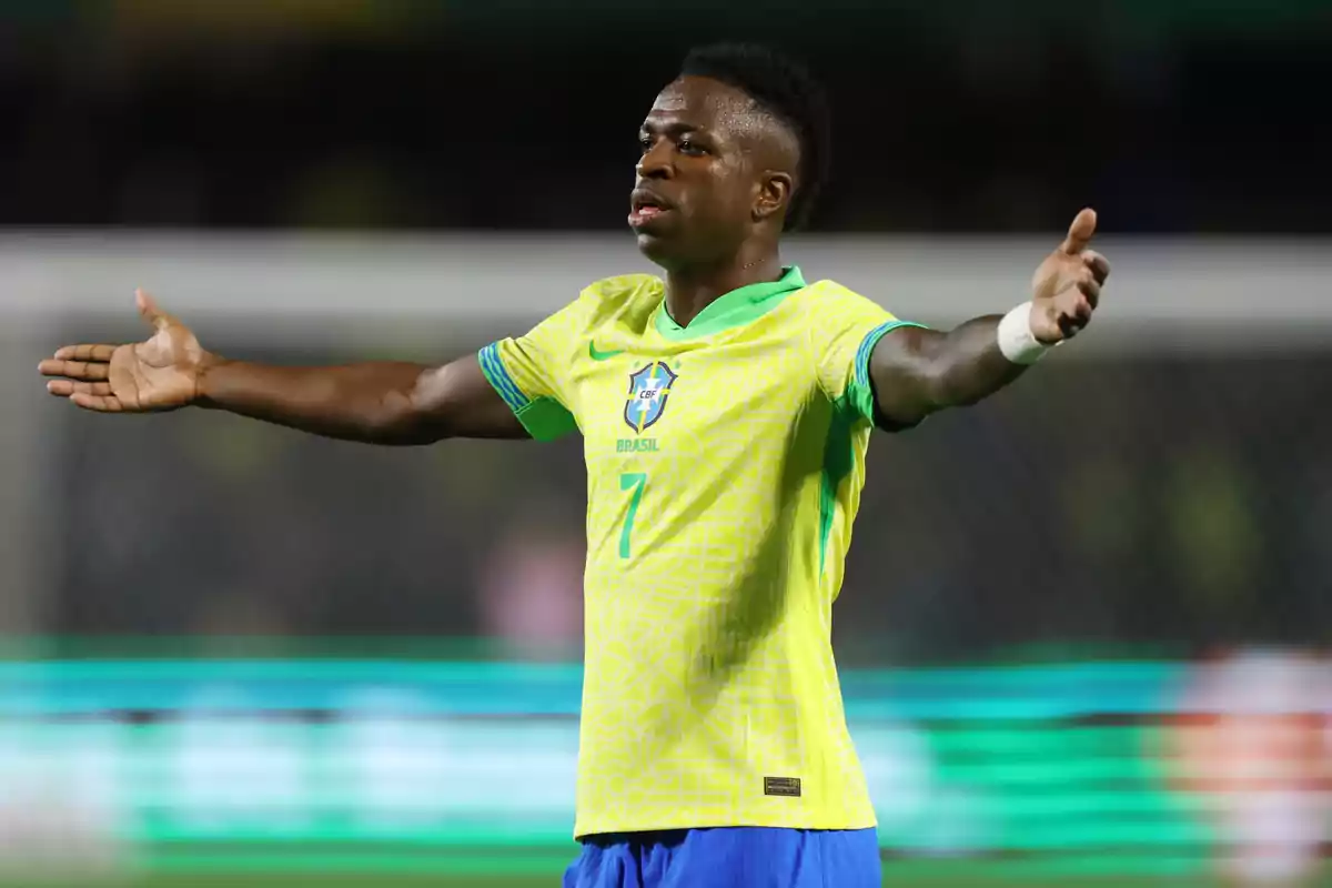 A soccer player in a Brazilian uniform spreads his arms on the field.