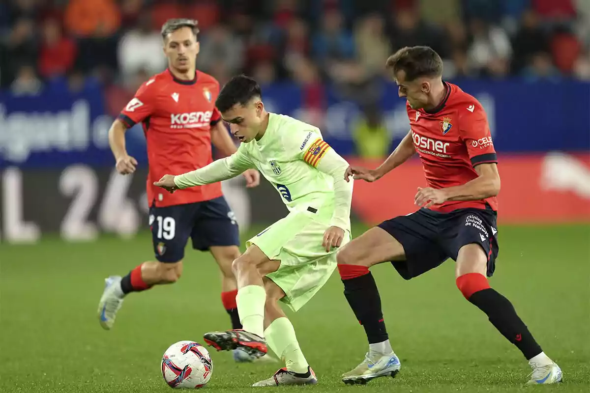 Jugadores de fútbol compitiendo por el balón en un partido.