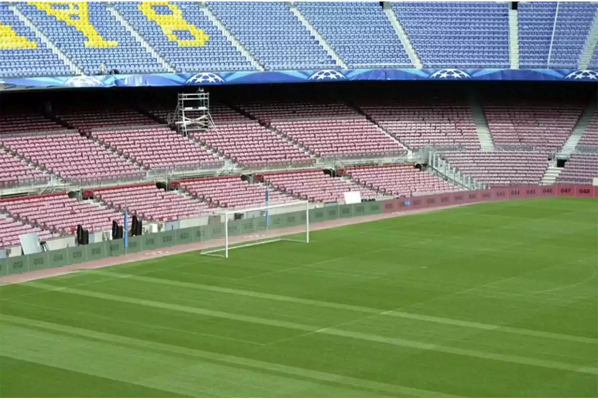 Empty soccer stadium with pink and blue stands and a goal in the foreground