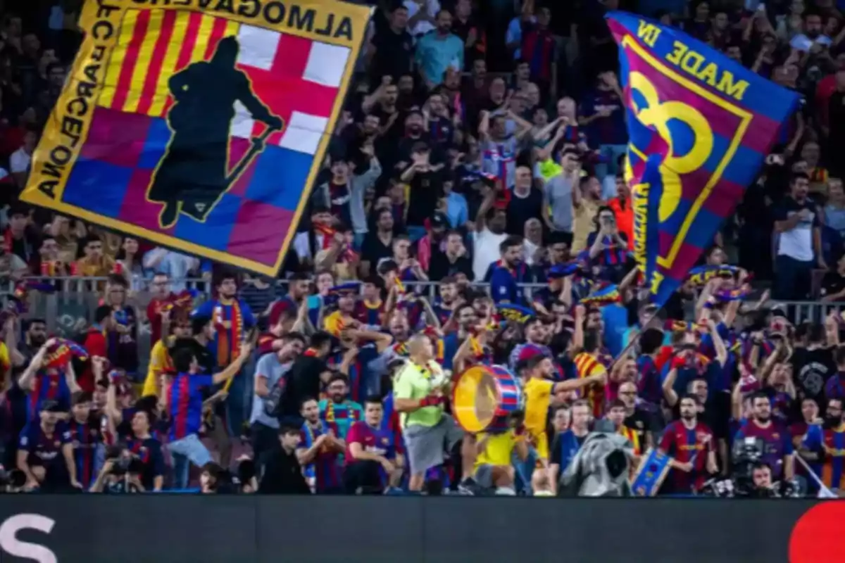 Fans cheering in a stadium with team flags and scarves.