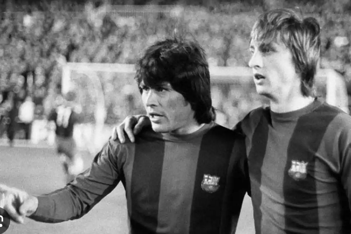 Two FC Barcelona players on the field during a match in black and white.