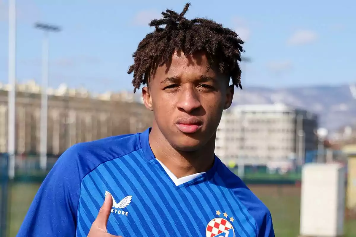 Young player wearing a blue jersey posing outdoors on a sports field Young player wearing a blue jersey posing outdoors on a sports field
