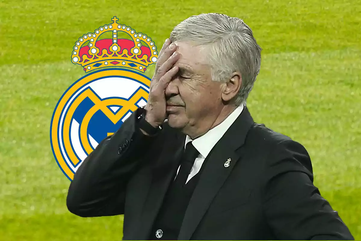 Carlo Ancelotti se cubre la cara con una mano, con el escudo del Real Madrid de fondo.