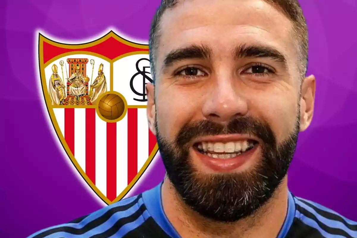 A smiling man with a beard in front of the Sevilla FC crest on a purple background.