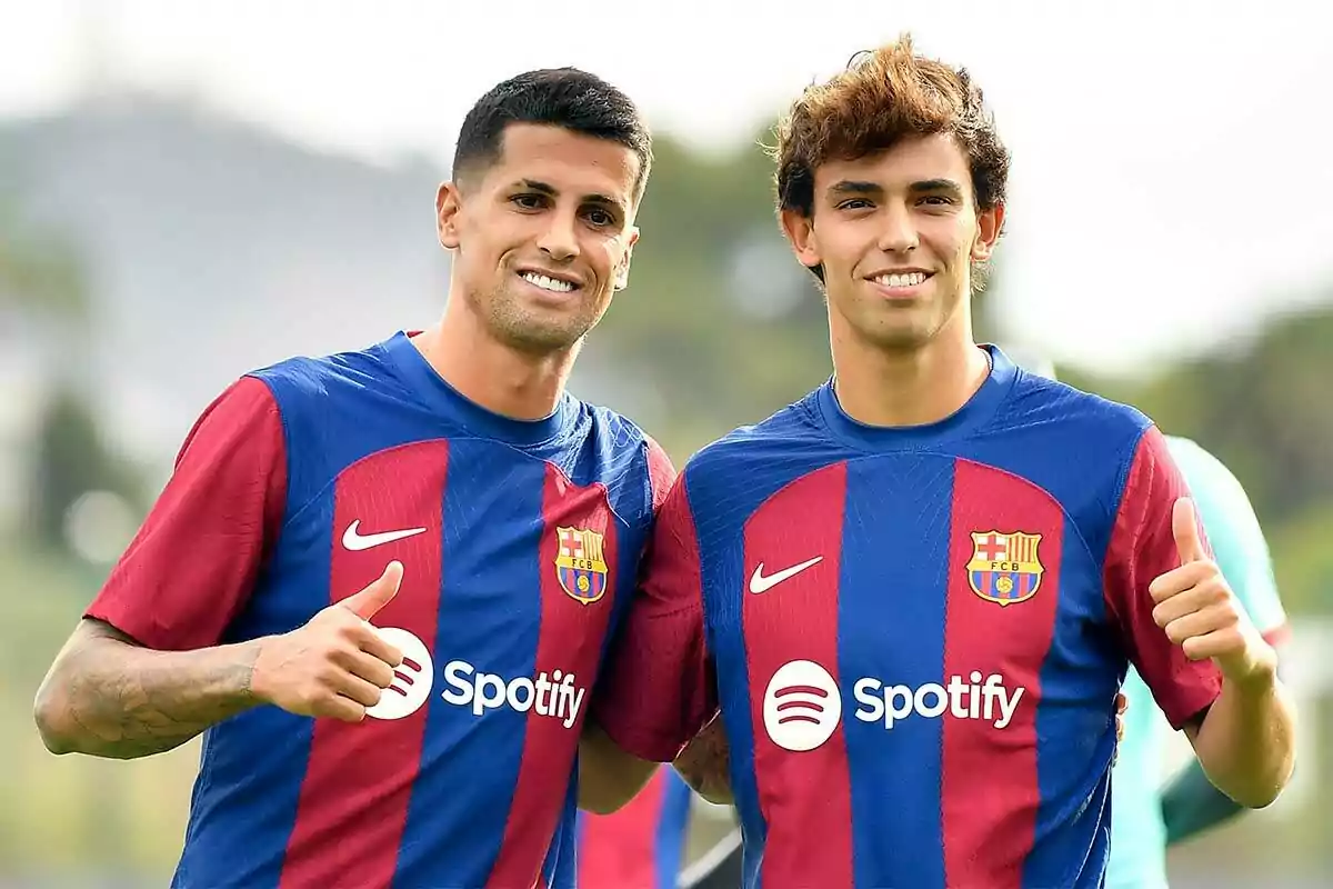 Joao Cancelo y Joao Félix posan con el uniforme del Barcelona y levantan el pulgar.