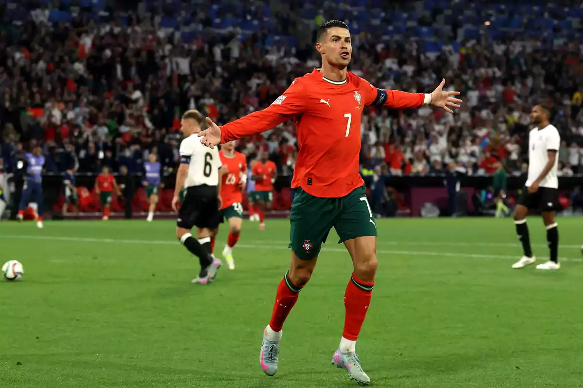 Futbolista con uniforme rojo celebrando un gol en un estadio lleno de aficionados Futbolista con uniforme rojo celebrando un gol en un estadio lleno de aficionados