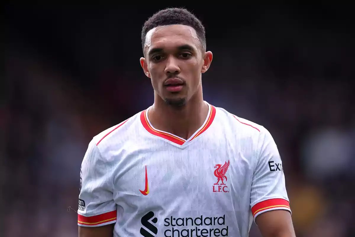 A soccer player in Liverpool FC uniform on the field.