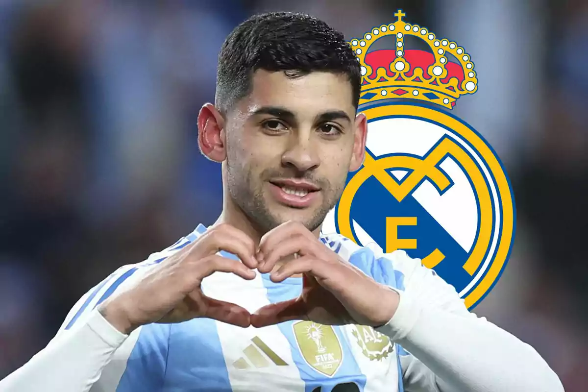 Cuti Romero con la camiseta de Argentina hace un gesto de corazón con las manos, con el escudo del Real Madrid de fondo.