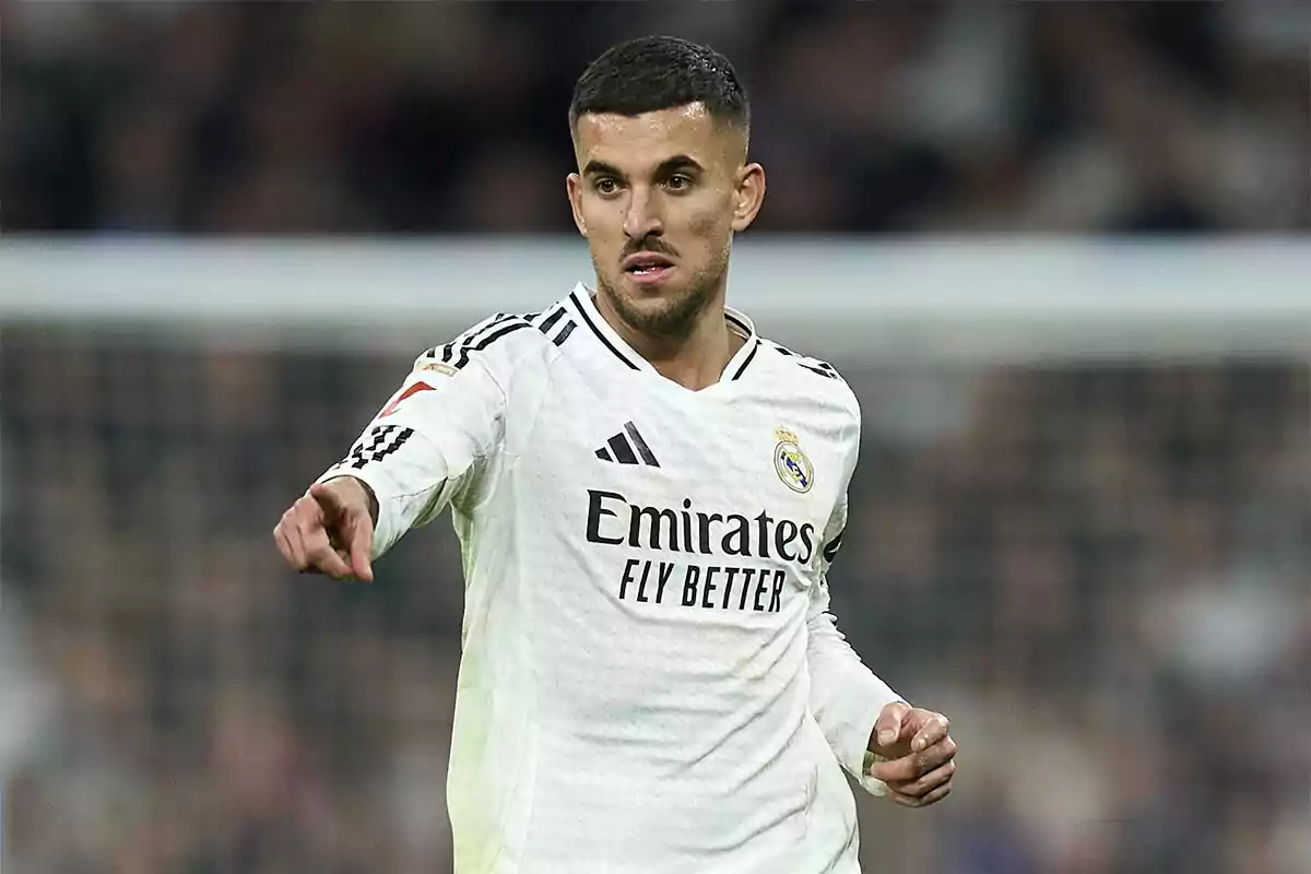 Un jugador de fútbol con el uniforme blanco del Real Madrid señalando durante un partido.