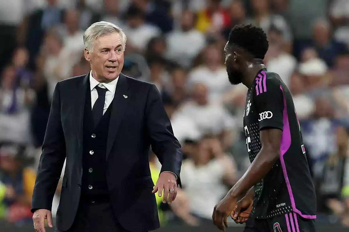 Ancelotti y Davies charlan sonriendo