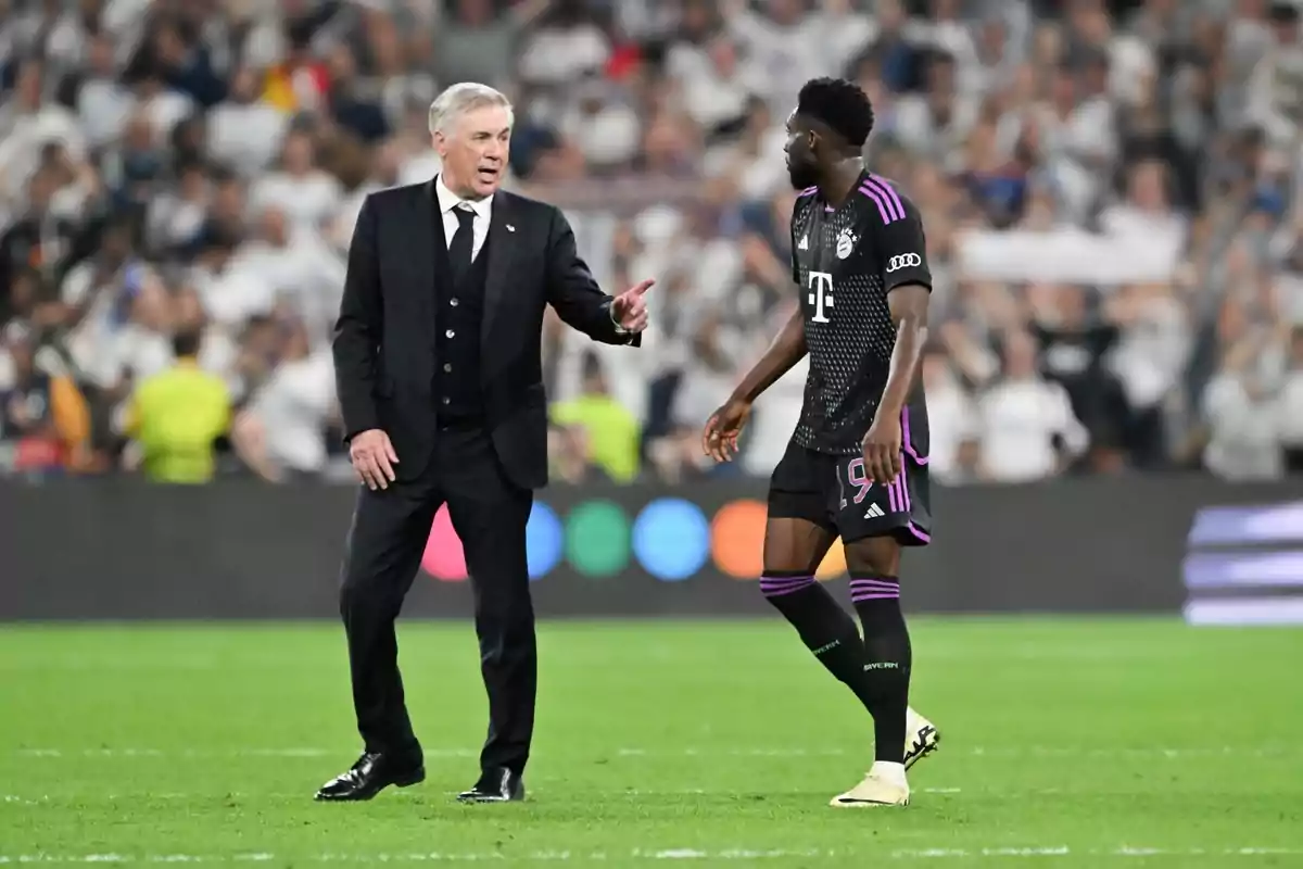 Un entrenador de fútbol hablando con un jugador en el campo durante un partido. Un entrenador de fútbol hablando con un jugador en el campo durante un partido.