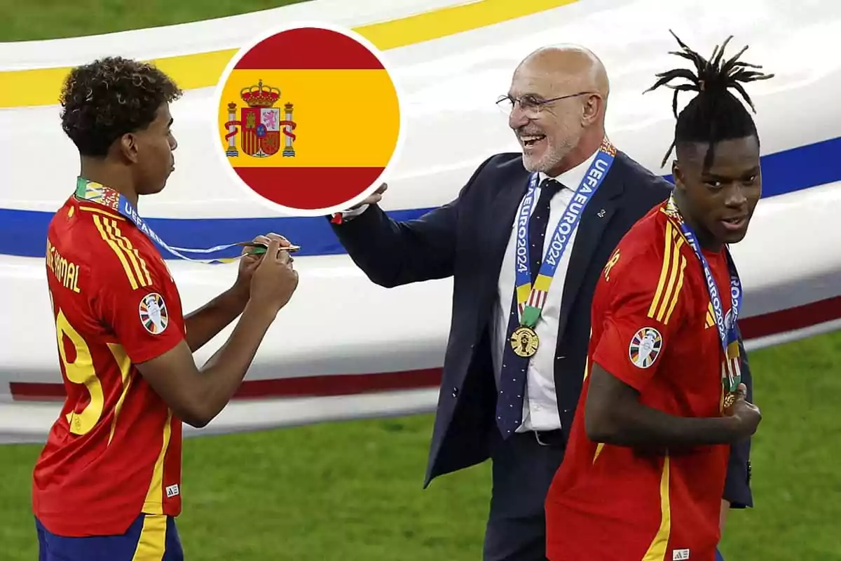 Jugadores de la selección española de fútbol celebran con medallas y Luis de la Fuente sonriente, con la bandera de España en el fondo.