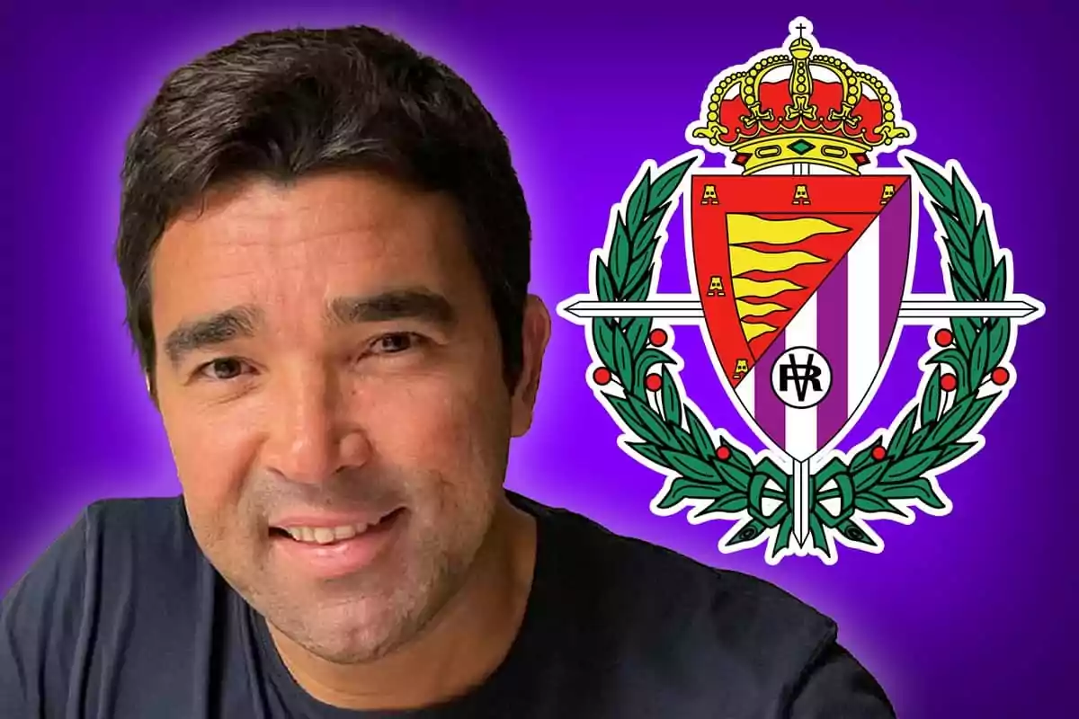 Un hombre sonriente con una camiseta oscura está frente a un fondo morado junto al escudo de un equipo de fútbol.