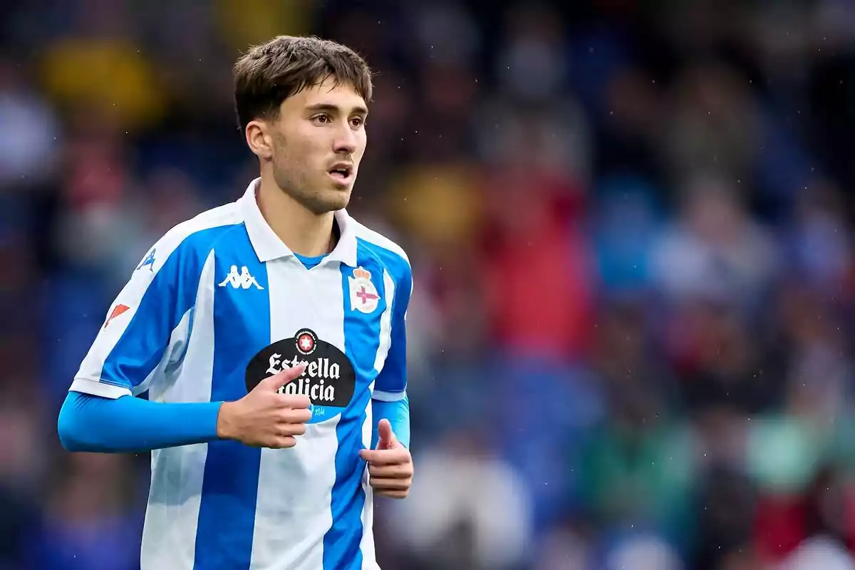 Jugador de fútbol con uniforme azul y blanco del Deportivo de La Coruña en un partido Jugador de fútbol con uniforme azul y blanco del Deportivo de La Coruña en un partido