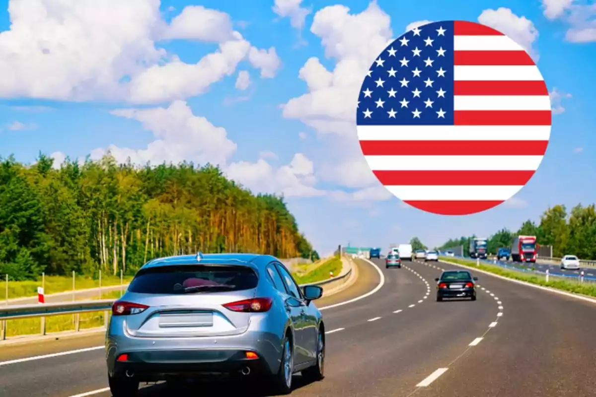 Carros circulando por una autopista rodeada de árboles bajo un cielo azul con nubes y un círculo con la bandera de Estados Unidos en la esquina superior derecha
