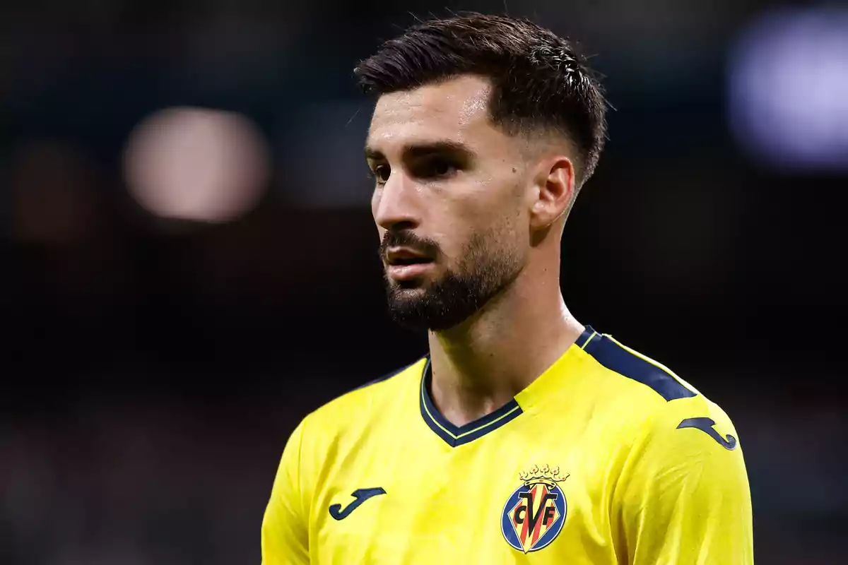 Jugador de fútbol con camiseta amarilla del Villarreal en el campo.