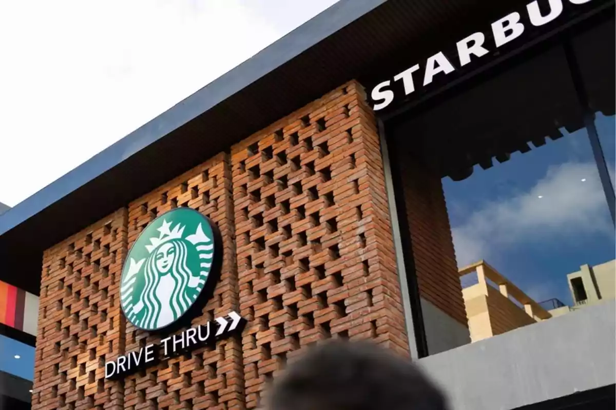 Fachada de un establecimiento de café con un letrero de drive-thru y un diseño de ladrillos. Fachada de un establecimiento de café con un letrero de drive-thru y un diseño de ladrillos.