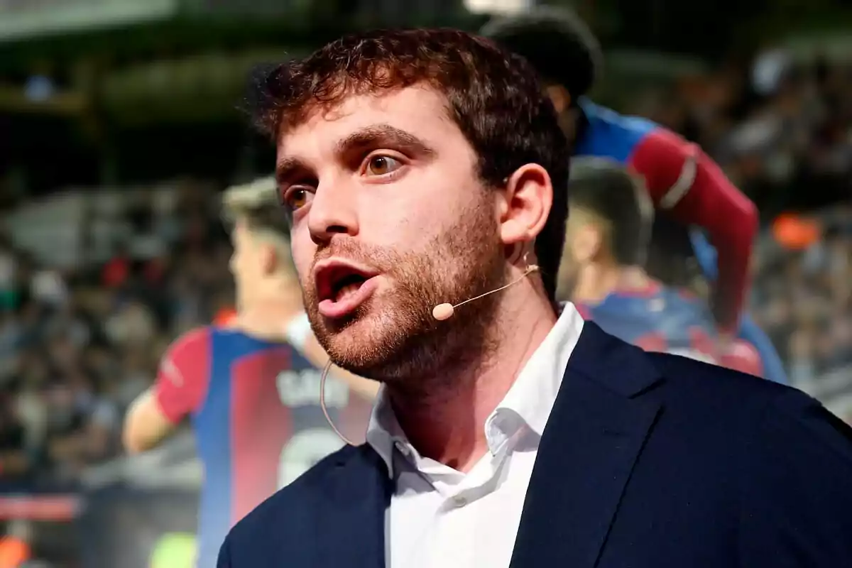 Fabrizio Romano con micrófono de diadema hablando con jugadores del FC Barcelona en su espalda.
