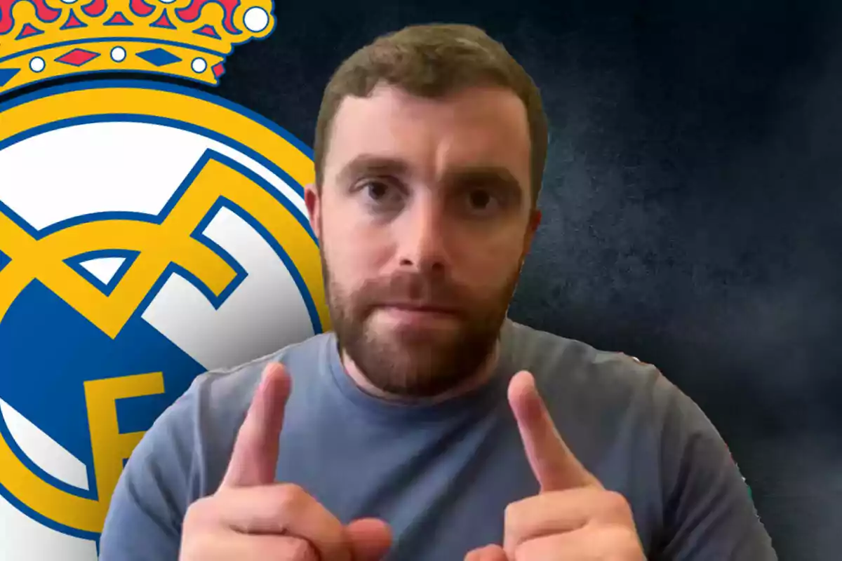 Fabrizio Romano con barba y camiseta gris señala hacia adelante con ambas manos frente a un fondo con el escudo del Real Madrid.