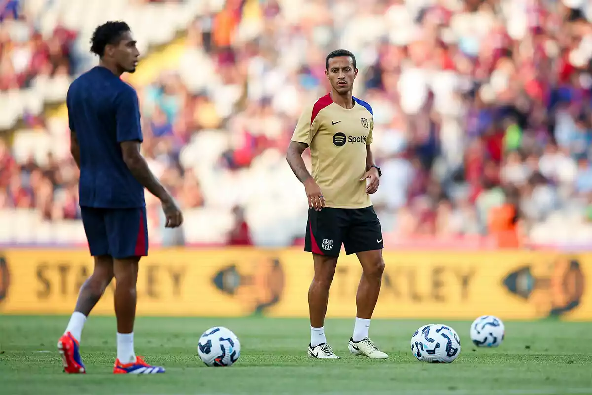 Thiago Alcántara en el campo durante un entrenamiento con balones a su alrededor y una multitud en el fondo. Thiago Alcántara en el campo durante un entrenamiento con balones a su alrededor y una multitud en el fondo.
