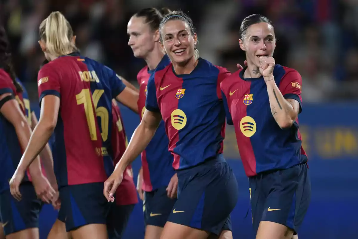 FC Barcelona women's players celebrating on the field in blue and maroon uniforms. FC Barcelona women's players celebrating on the field in blue and maroon uniforms.