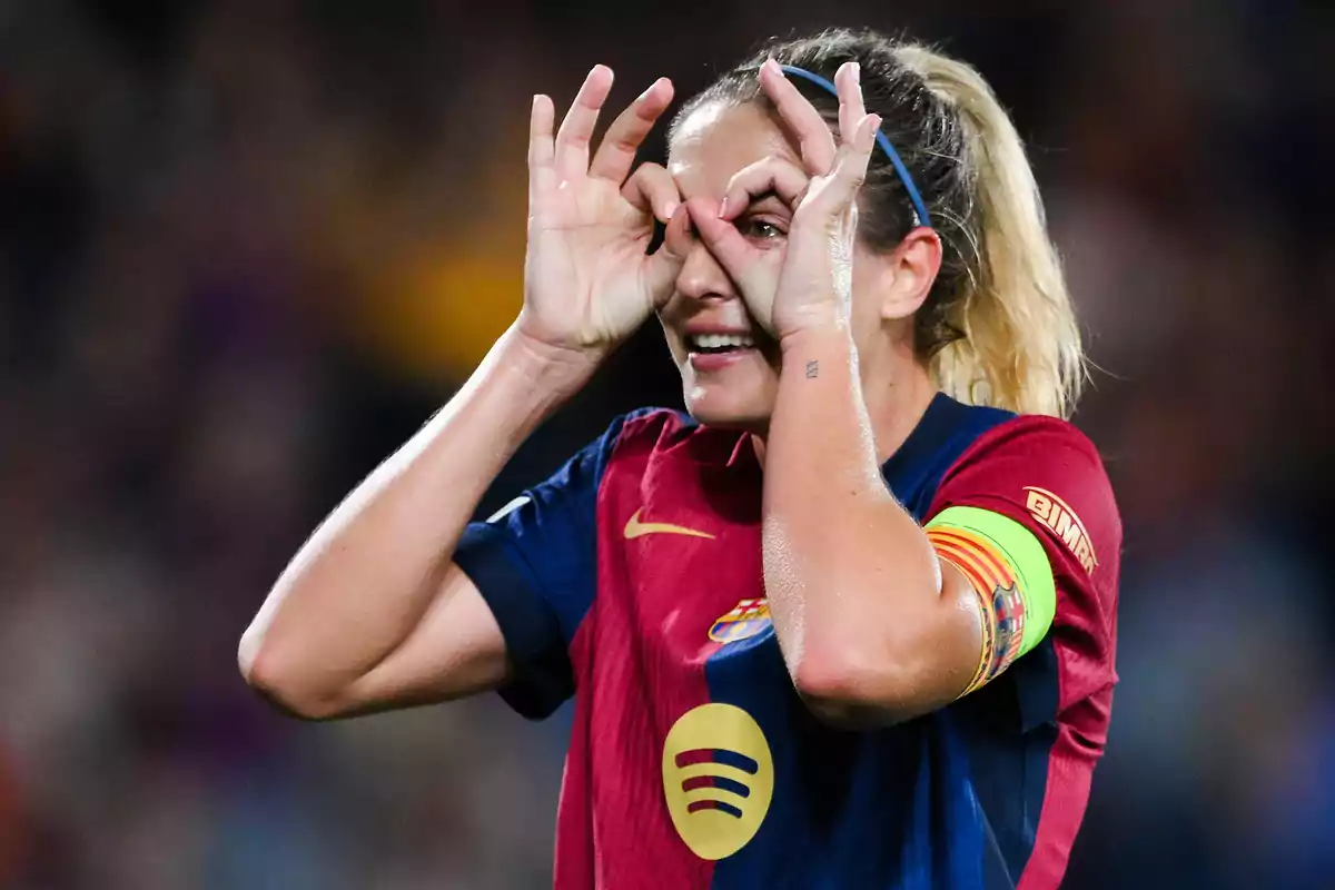 Female player in blue and red uniform making funny hand gesture on field. Female player in blue and red uniform making funny hand gesture on field.