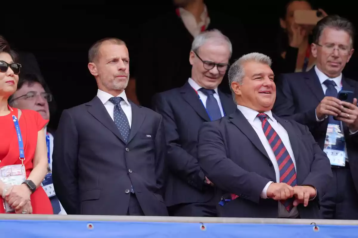A group of formally dressed people watching a sporting event from a box seat. A group of formally dressed people watching a sporting event from a box seat.