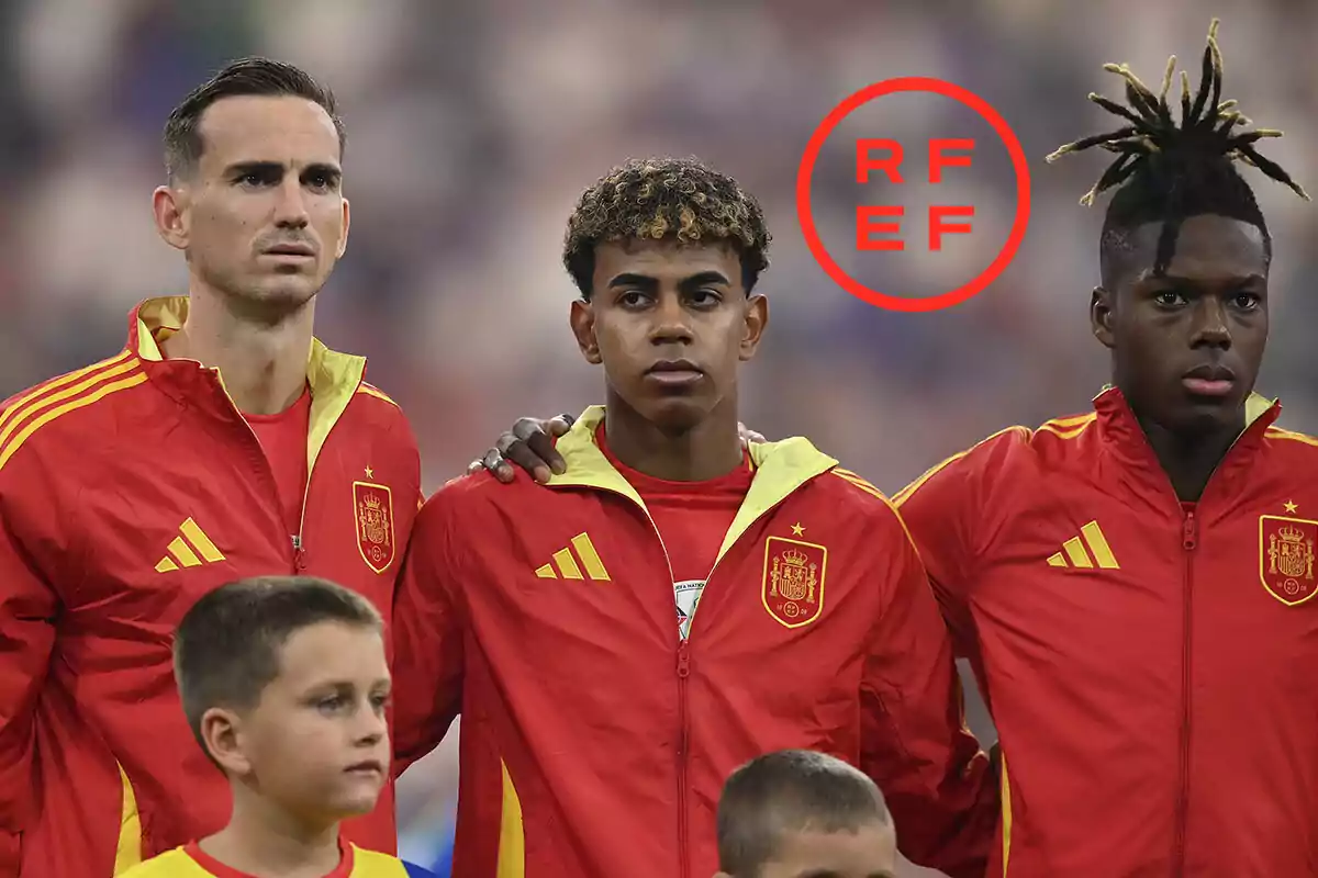 Jugadores de la selección española de fútbol con chaquetas rojas y amarillas durante el himno nacional.