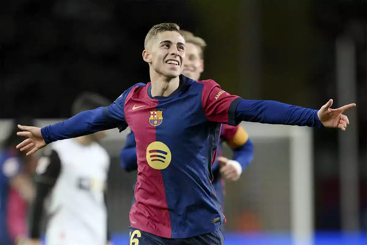 Un jugador de fútbol celebrando un gol con los brazos extendidos vistiendo el uniforme del FC Barcelona. Un jugador de fútbol celebrando un gol con los brazos extendidos vistiendo el uniforme del FC Barcelona.