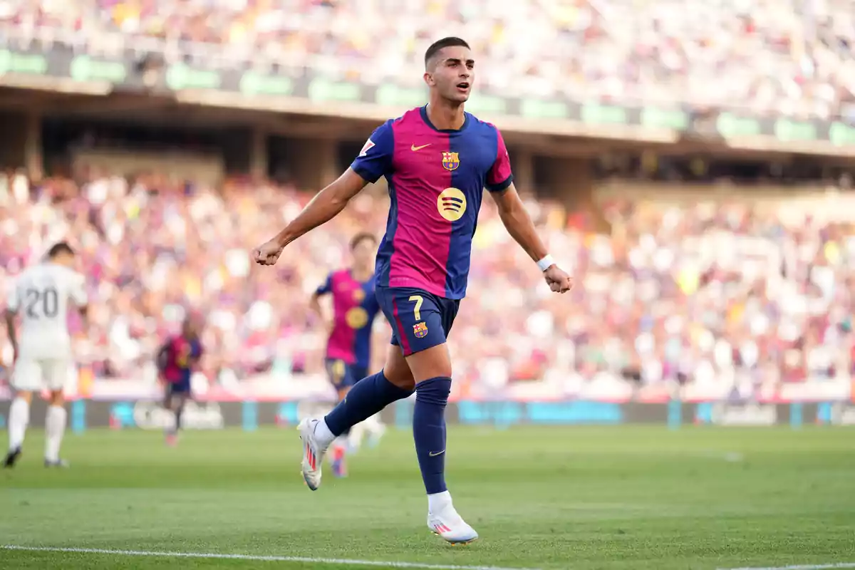 Soccer player celebrating a goal in a stadium full of spectators.