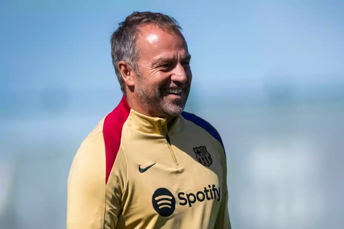 Hombre sonriendo con una chaqueta del FC Barcelona y el logo de Spotify