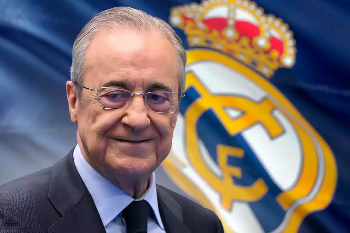 Florentino Pérez con gafas y traje oscuro frente a una bandera del Real Madrid.