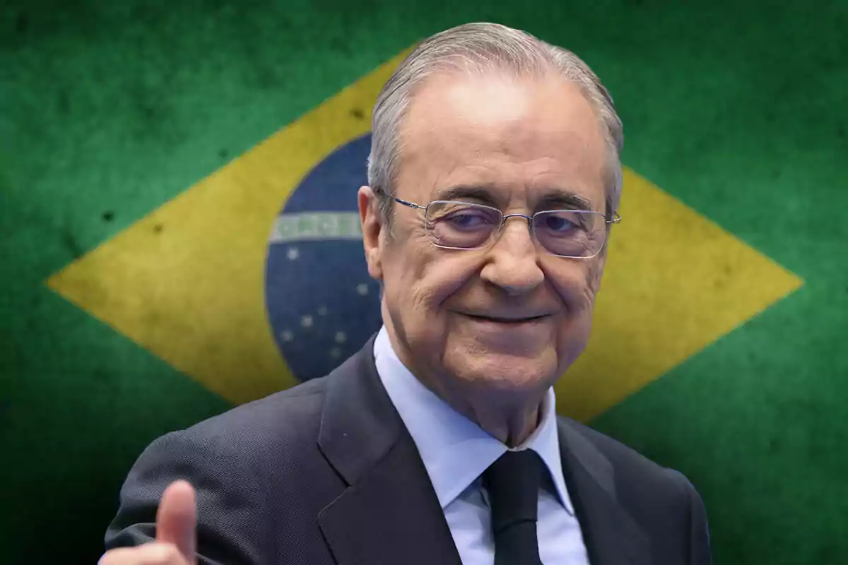 Florentino Pérez with glasses and dark suit smiling in front of a Brazilian flag.