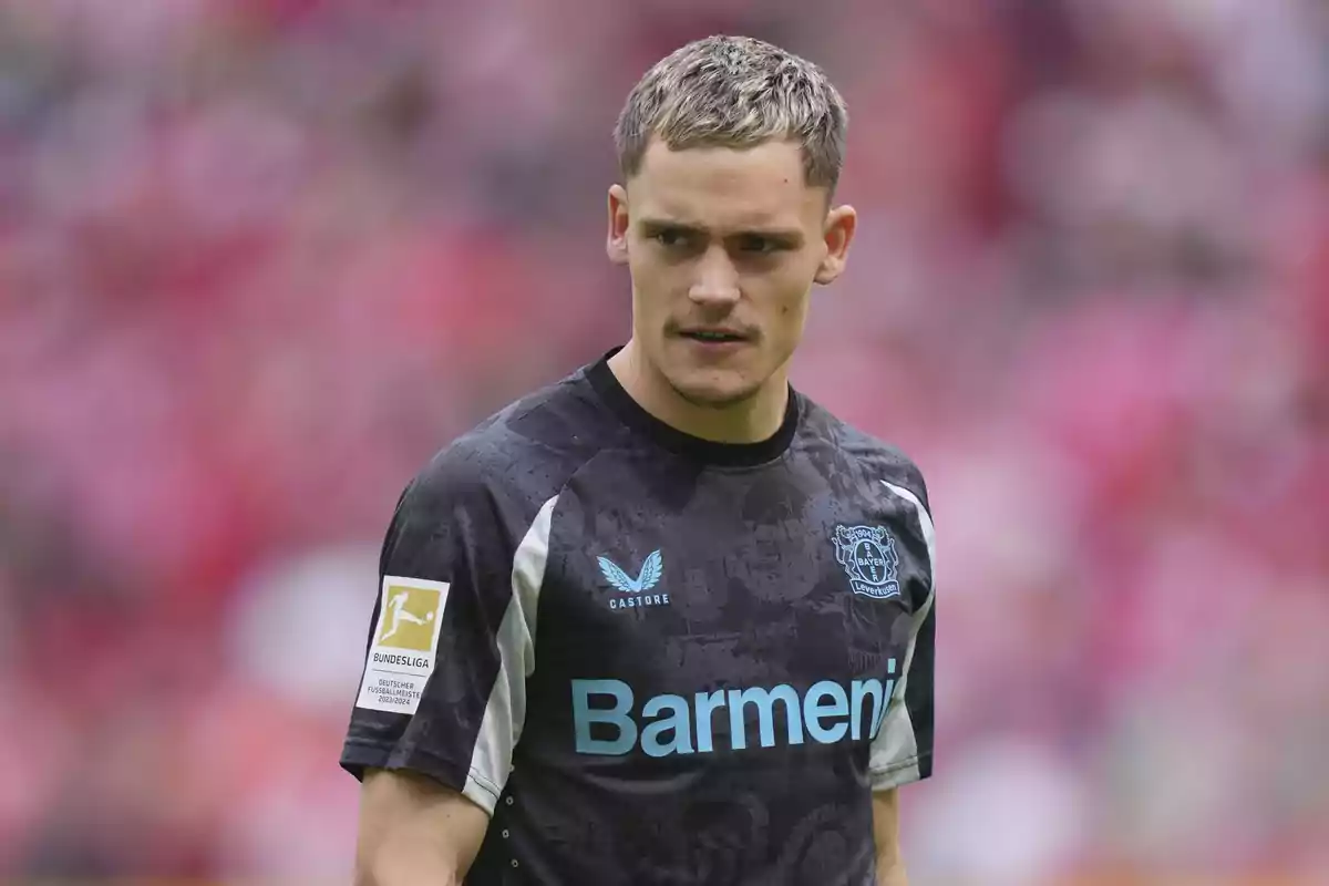 Un jugador de fútbol con camiseta negra del Bayer Leverkusen en el campo. Un jugador de fútbol con camiseta negra del Bayer Leverkusen en el campo.