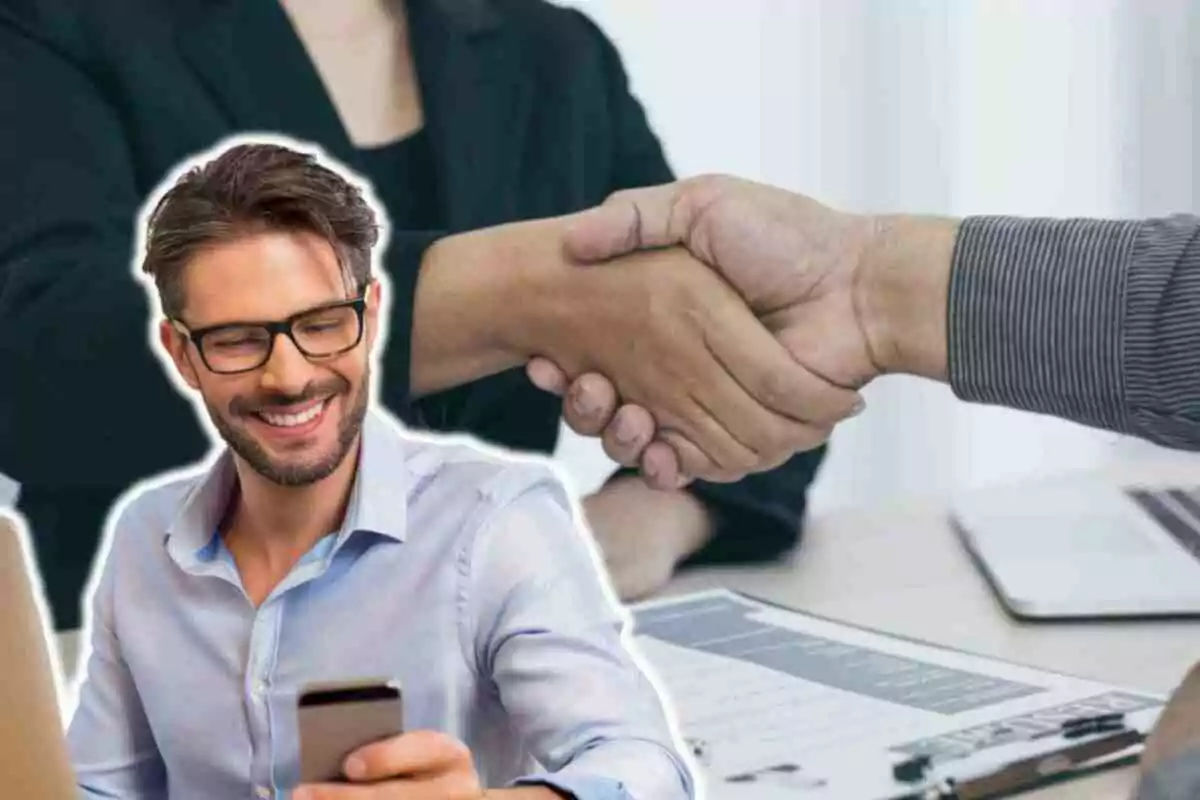 Un hombre sonriente con gafas y barba mira su teléfono móvil mientras dos personas se dan la mano en el fondo, sugiriendo un acuerdo o colaboración. Un hombre sonriente con gafas y barba mira su teléfono móvil mientras dos personas se dan la mano en el fondo, sugiriendo un acuerdo o colaboración.
