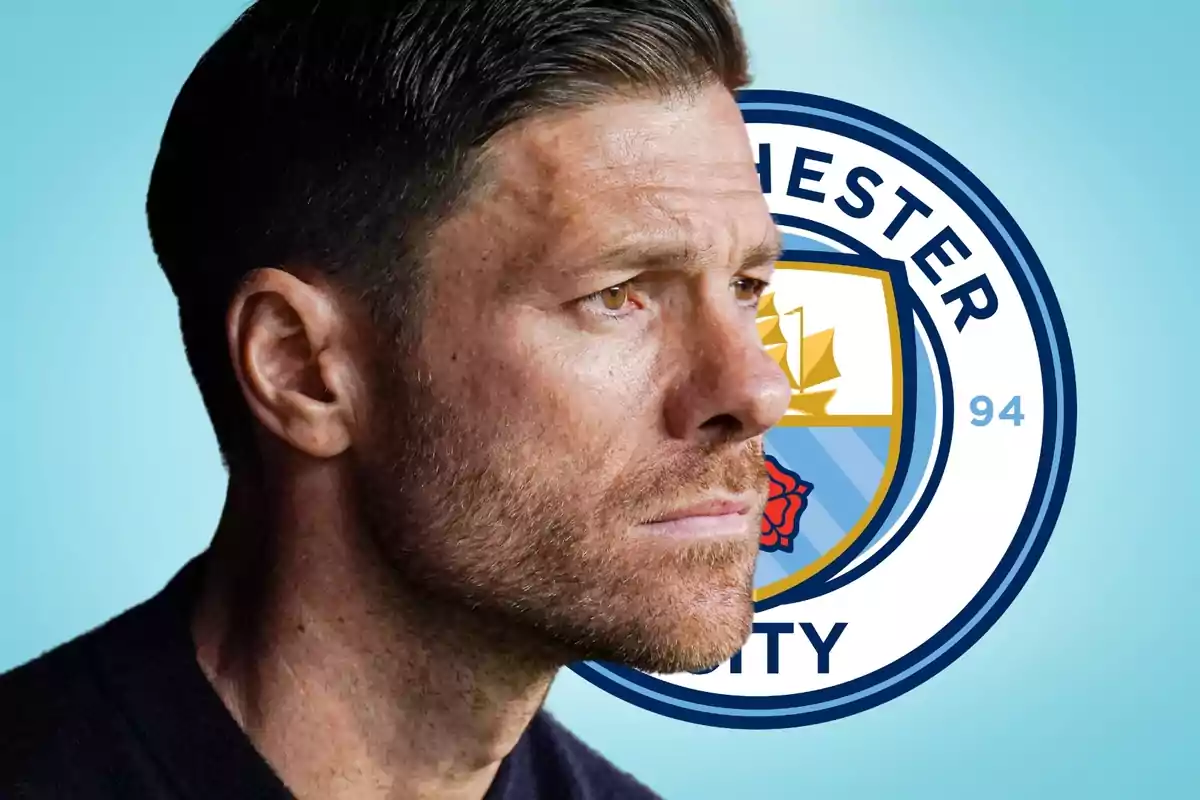 Un hombre de perfil con el logo del Manchester City de fondo.