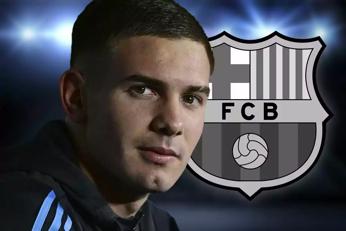 A young man with short hair looks at the camera with the FC Barcelona crest in black and white in the background.