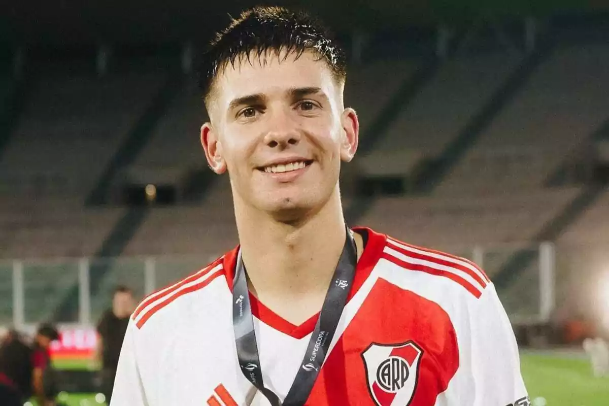 Franco Mastantuono posing with the River Plate shirt with a medal hanging around his neck