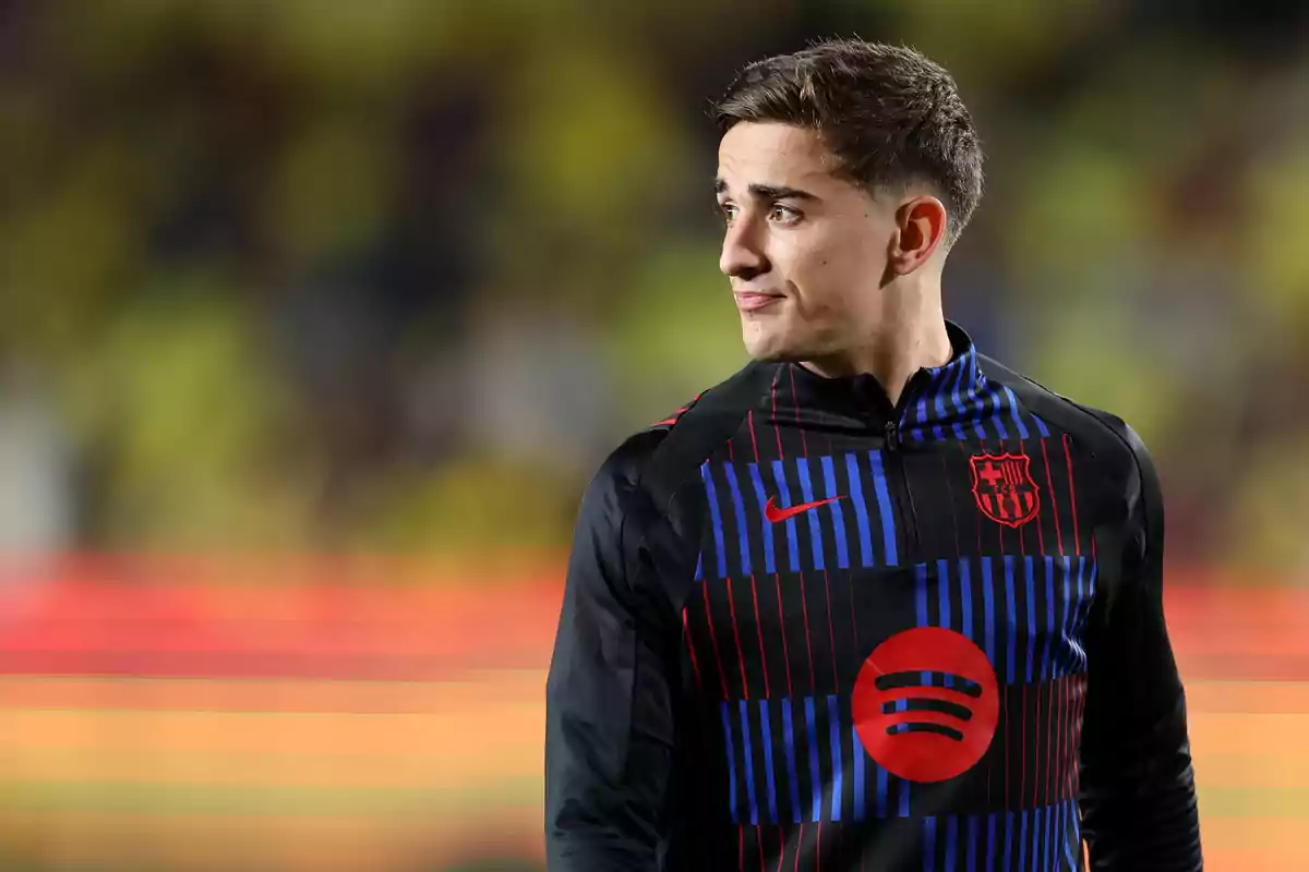 A player in an FC Barcelona uniform looks to the side on a playing field.