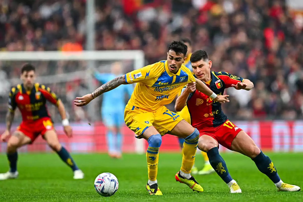 Two players fight for the ball during a match while other players watch the play in the background. Two players fight for the ball during a match while other players watch the play in the background.