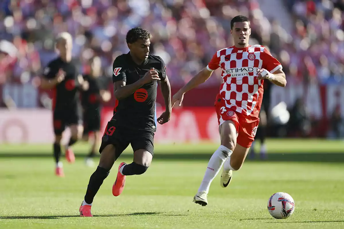 Lamine Yamal y Miguel Gutiérrez compiten por el balón en un partido.