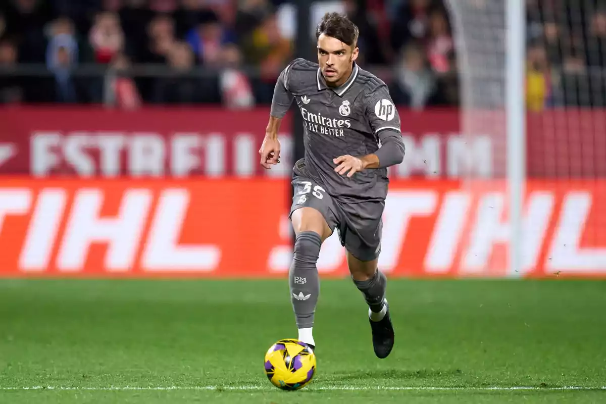 A soccer player in a gray uniform runs with the ball on a playing field. A soccer player in a gray uniform runs with the ball on a playing field.
