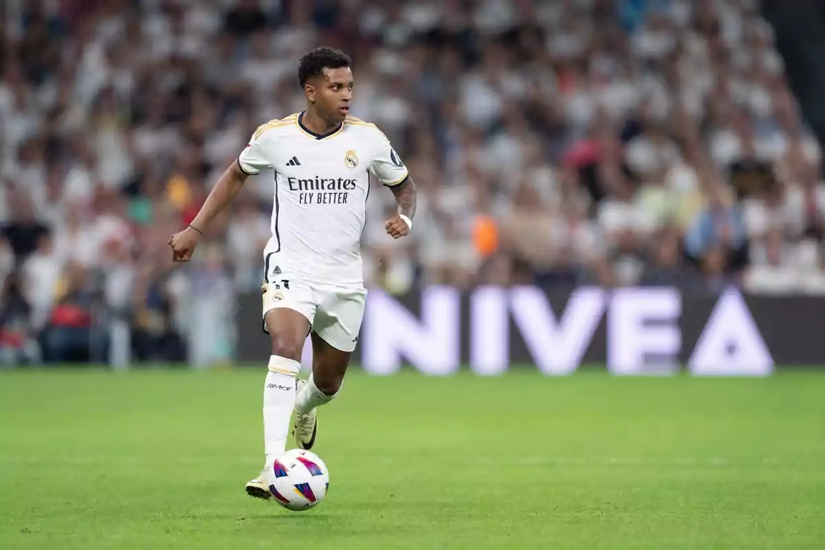 A Real Madrid soccer player running with the ball in a match.